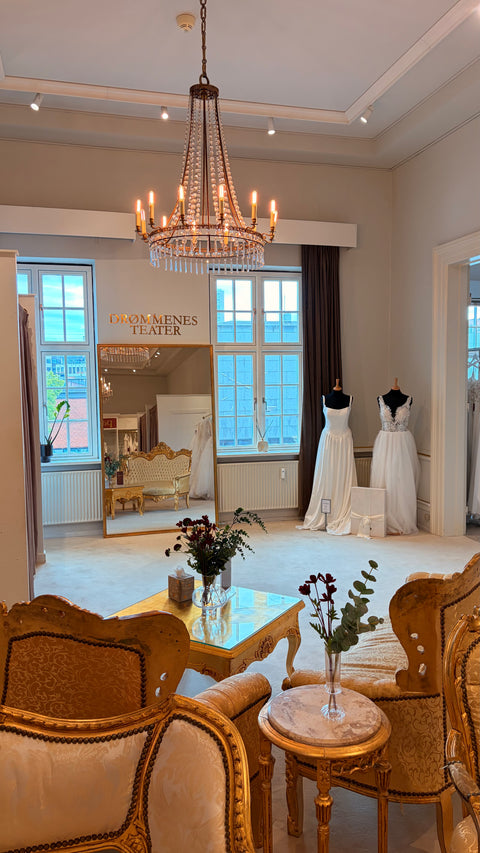 Panayotis brudekjolebutik i Vejle med eksklusive brudekjoler, elegant showroom, stort guldspejl og luksuriøse prøverum.